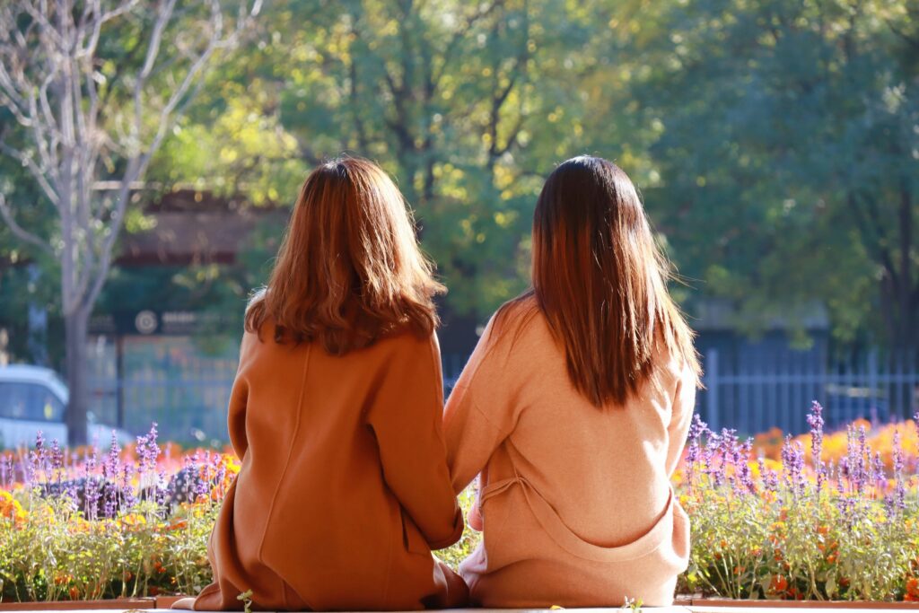 Two people sitting close together in a calm, connected moment, illustrating co-regulation within the window of tolerance.