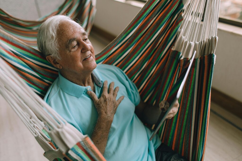 Person sitting quietly with hand on chest, aware of their heartbeat and nervous system state.