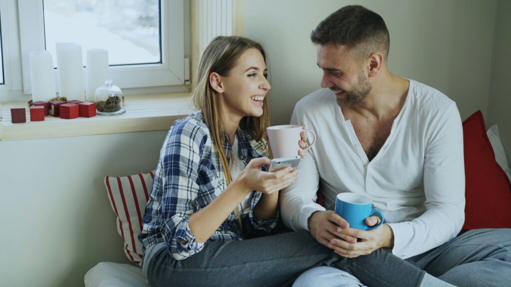 Two people in easy, relaxed connection during an ordinary moment, representing the everyday safety that underlies intimacy.