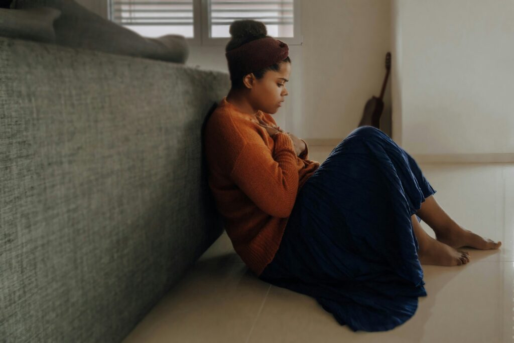 Person sitting in a contracted position, experiencing the overwhelm of an emotional flashback.