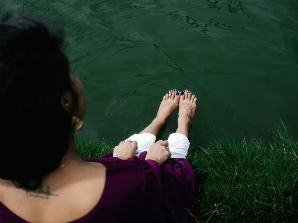 Person sitting outdoors in quiet reflection, having worked through a difficult relationship decision.