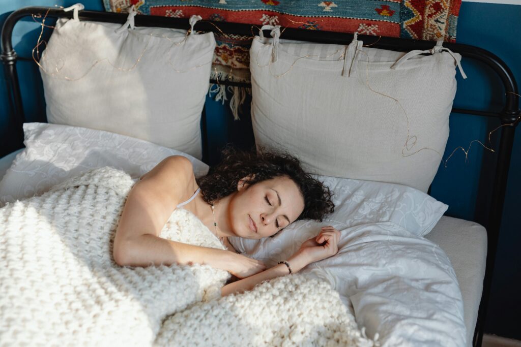 Person resting comfortably under a weighted blanket, nervous system settled for sleep.