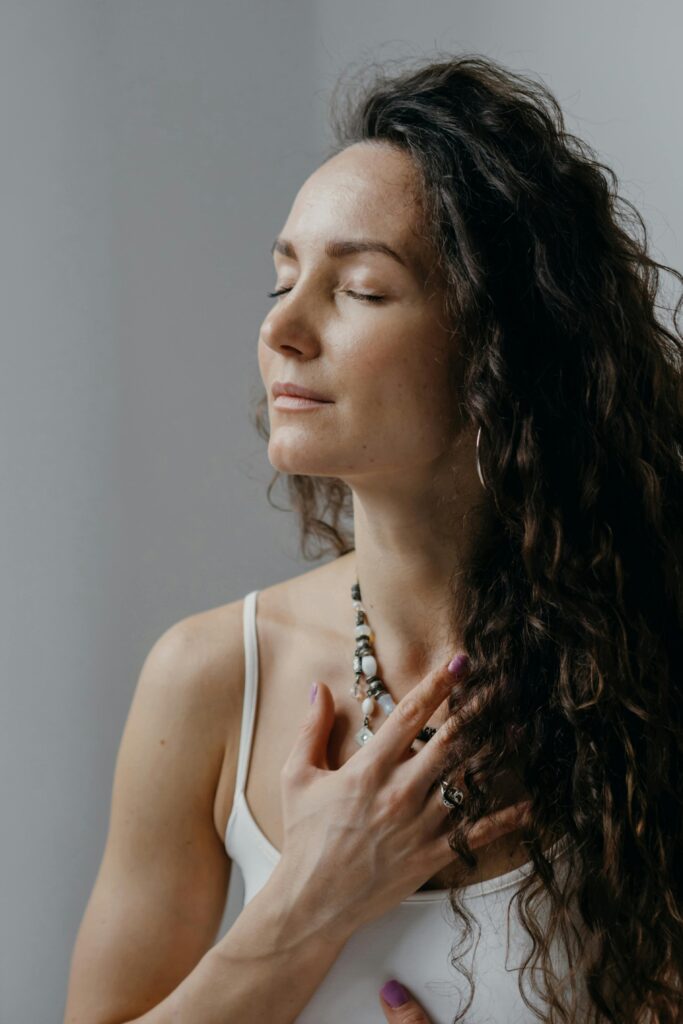 Person with hand on chest, practicing somatic body awareness.